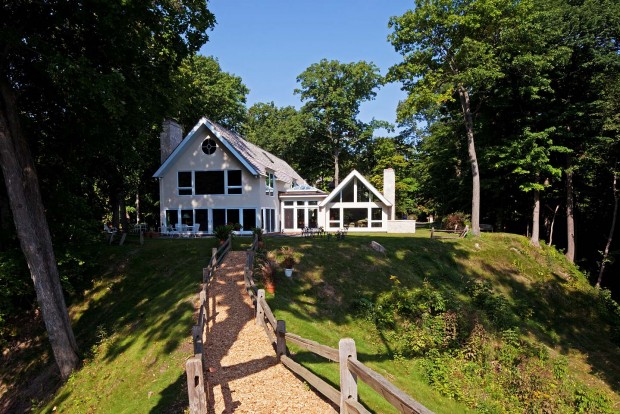 a rear exterior view of the home as seen when ascending a wood fenced path from the beach below, photographed by Jacob Rosenfeld